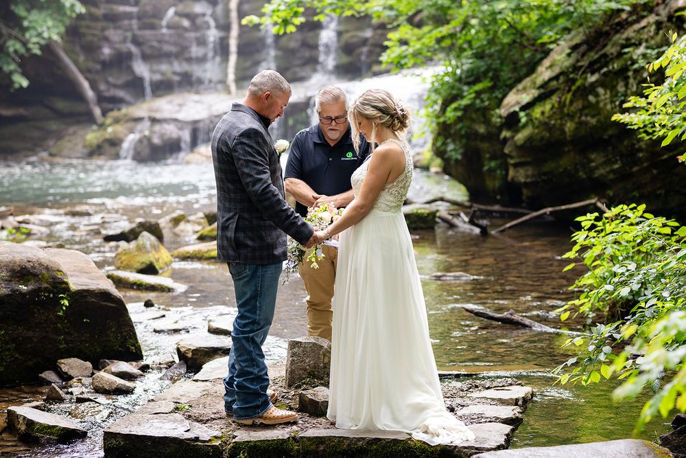 Couple exchanging vows on the rocks beside Mirror Lake Waterfall during their Ozark elopement, Mountain View, Arkansas