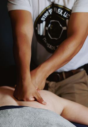 Licensed massage therapist performing deep tissue back massage on client at Stretch Flex massage studio.