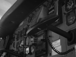 Black and white close-up of vintage aircraft cockpit instruments and radio equipment.