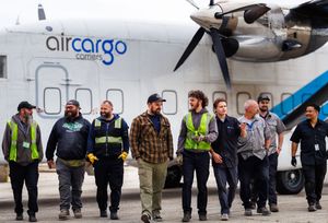 Air Cargo Carriers ground crew team walking together in front of a cargo aircraft.