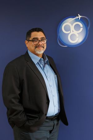 Professional man in blazer standing before Air Cargo Carriers company logo.