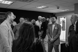 Black and white photo of professionals networking and conversing at a business event.