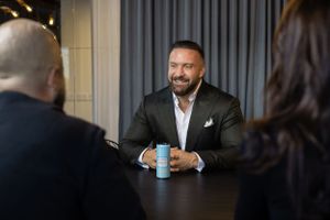 Pressfoto: Business people having meeting at conference table with person holding blue coffee cup while smiling.