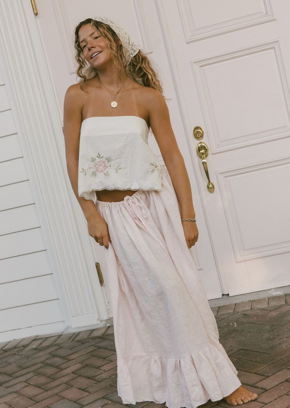 Woman in white summer dress poses playfully against white door in series of casual lifestyle photos.