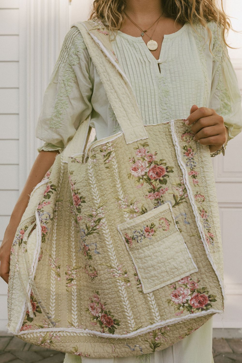 Vintage floral quilted tote bag with pink roses and cream stripes shown with white peasant blouse.