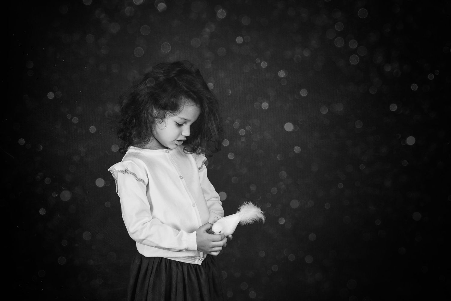 Hands holding baby on black background