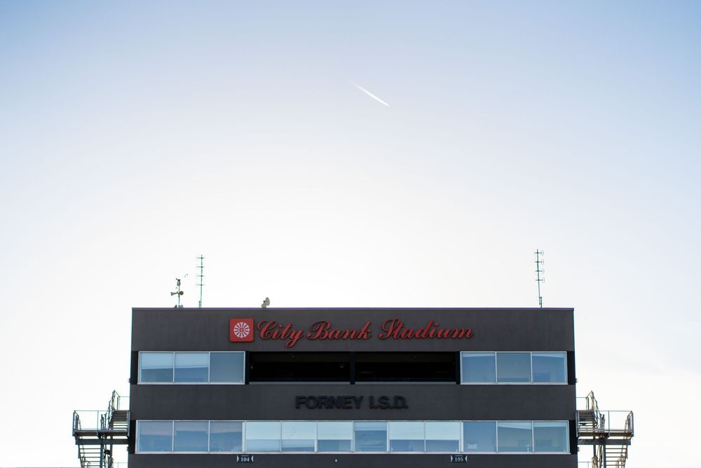 Stadium press box with Forney ISD signage against a clear blue sky.