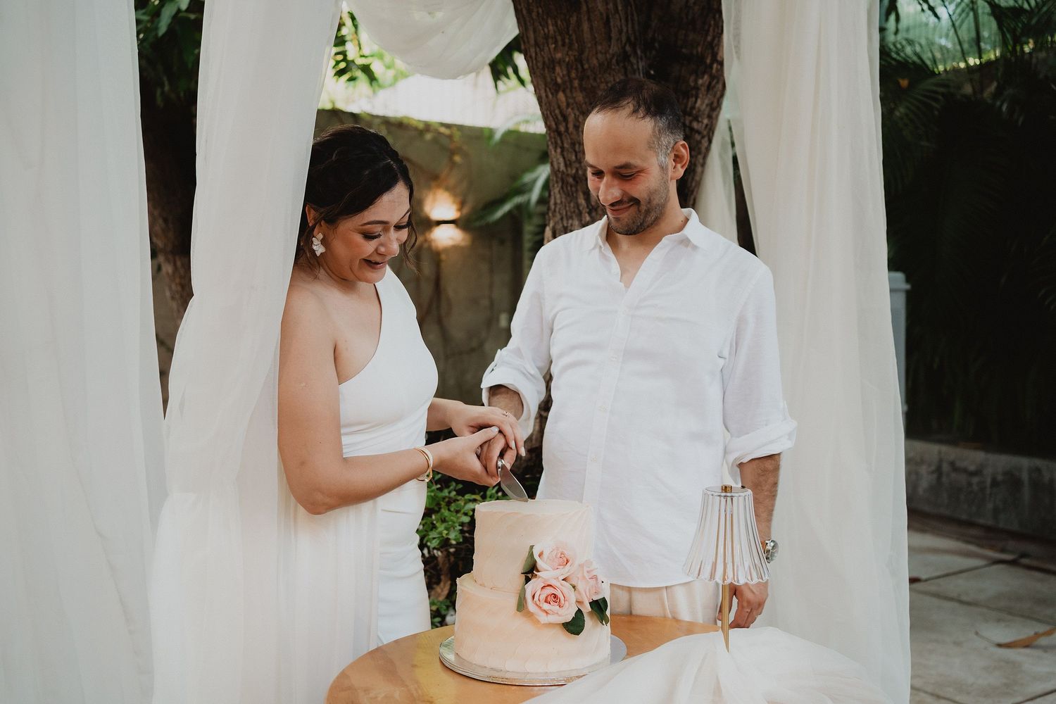 Los novios cortan el pastel durante la celebración de su boda íntima.