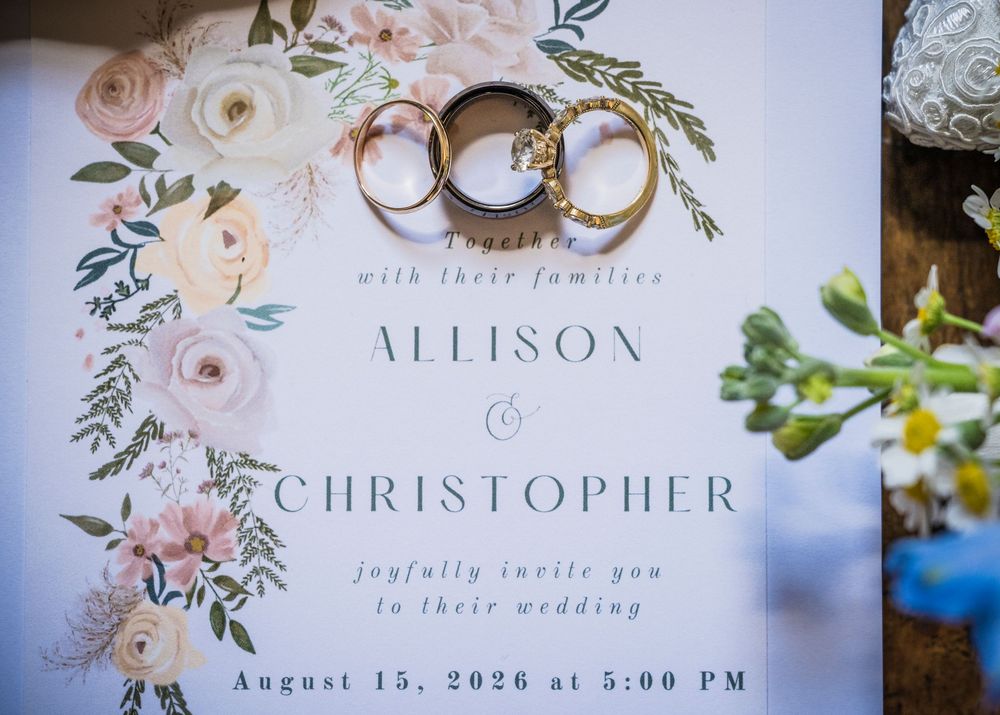 Elegant wedding invitation for Allison and Christopher with gold rings, floral design, dated August 15, 2026.