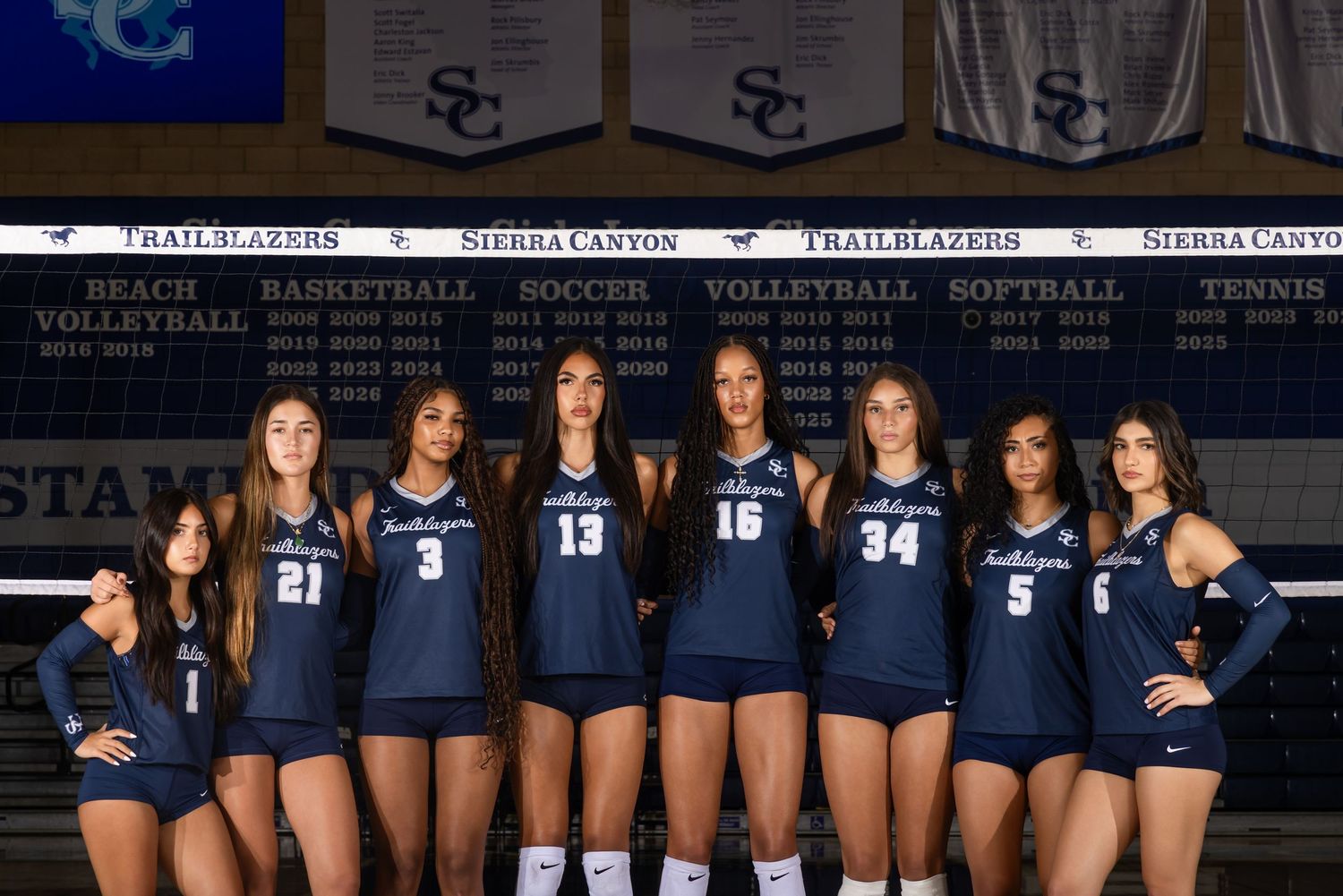 Sierra Canyon Trailblazers volleyball team poses together in uniform on their home court.