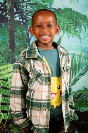 An image of a preschool learner happily smiling for their school portrait.