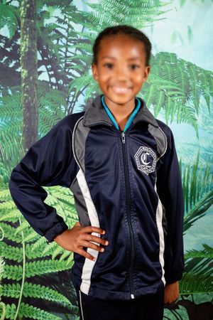 A picture of a learner posing for their school photo, while wearing their school uniform.