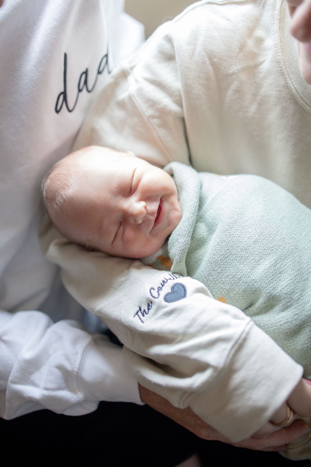 A newborn baby sleeping peacefully in mom's arms during fresh 48 session at the University of Tennessee with Nina Thomas Photography.