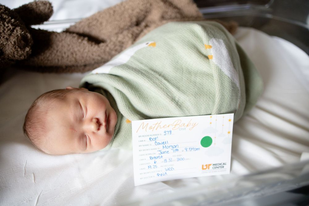 Newborn baby swaddled in green blanket during fresh 48 session at the University of Tennessee with Nina Thomas Photography.
