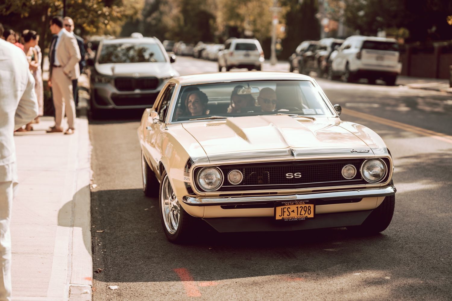 Classic Chevrolet Camaro SS muscle car parked on street at wedding venue.