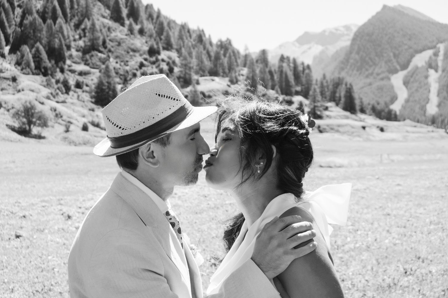 Le baiser des mariés dans un décor somptueux de montagne.Photo en noir et blanc chic.