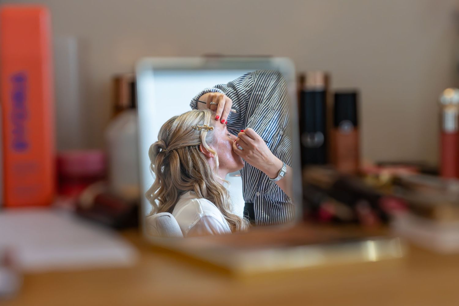 A makeup artist applying cosmetics to a bride on her wedding day. Candid photos for weddings. Sheffield, Rotherham, Yorkshire, Lincolnshire