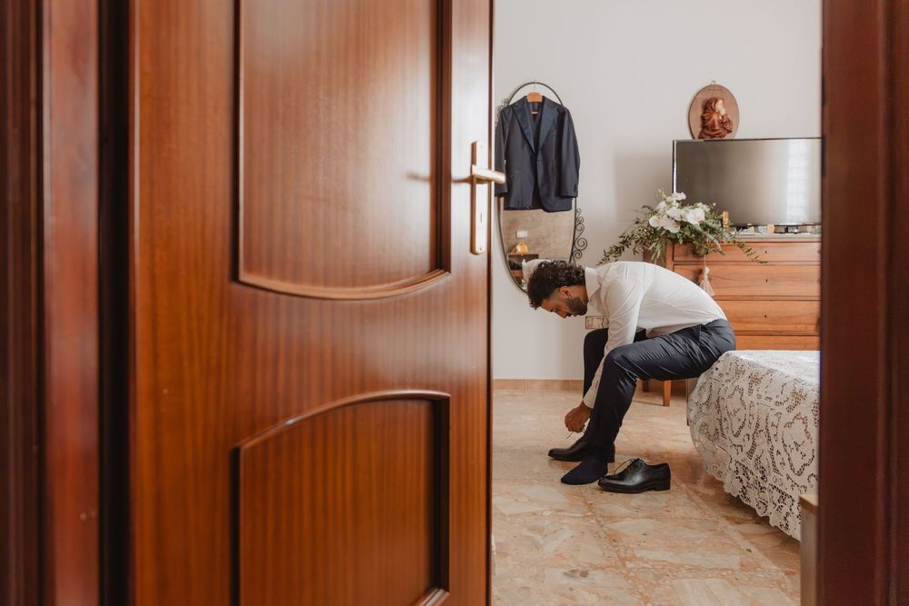 Lorenzo durante i preparativi, incorniciato dalla porta della stanza.
