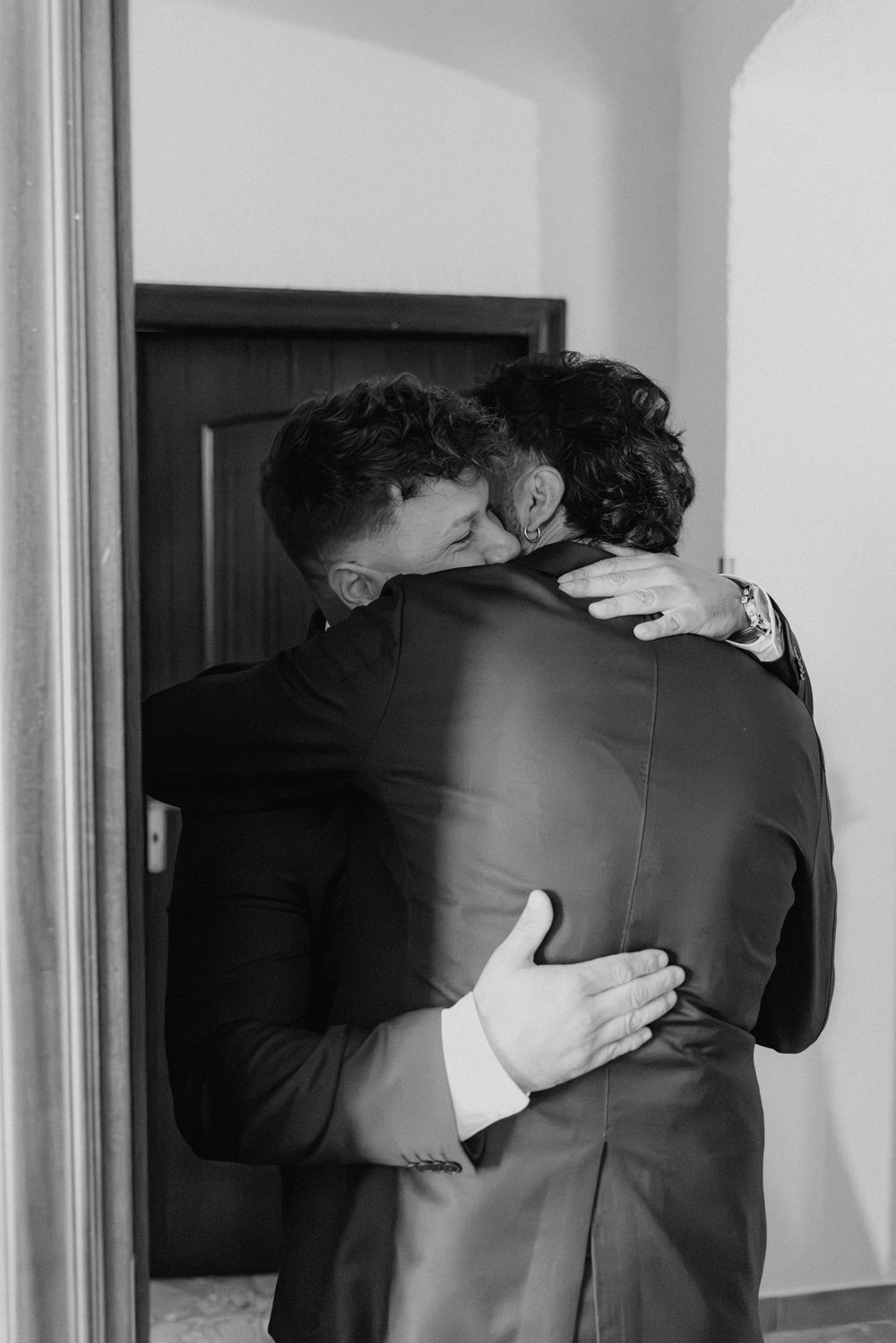 Un abbraccio a Lorenzo sulla soglia, fotografato in bianco e nero.