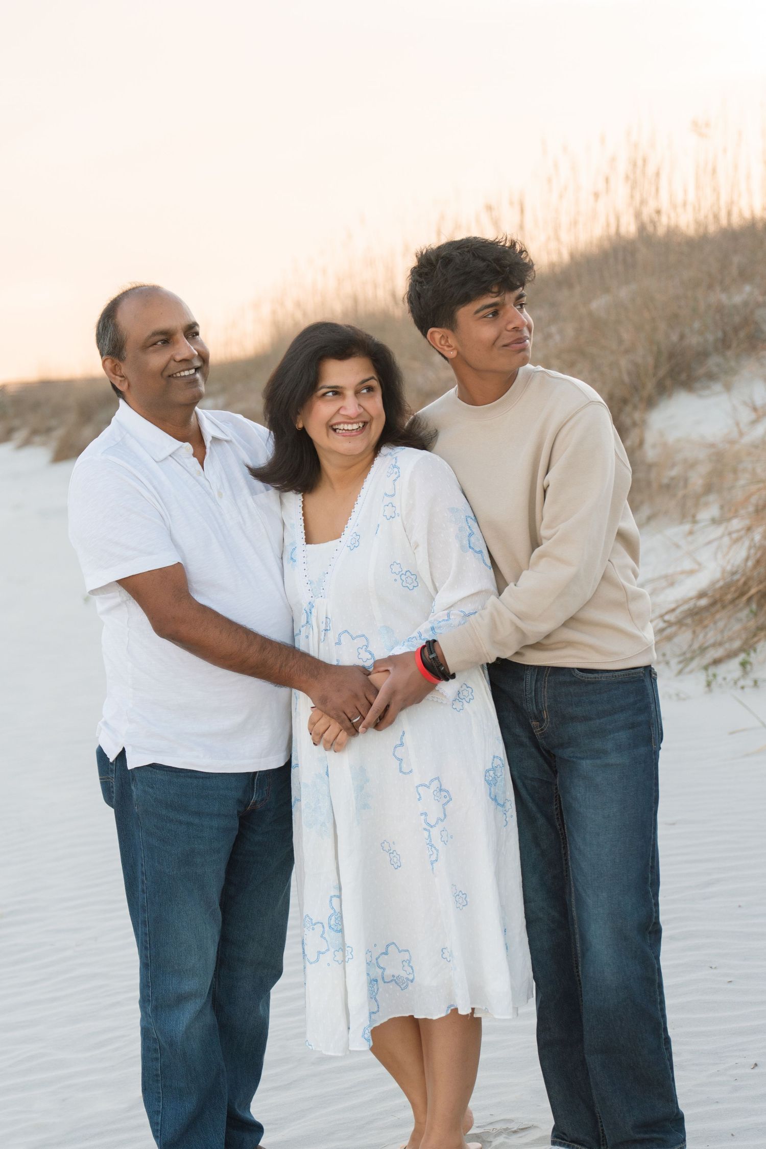 Parents and children embracing beside the ocean during a family portrait session with Lindy Rebro Photography.