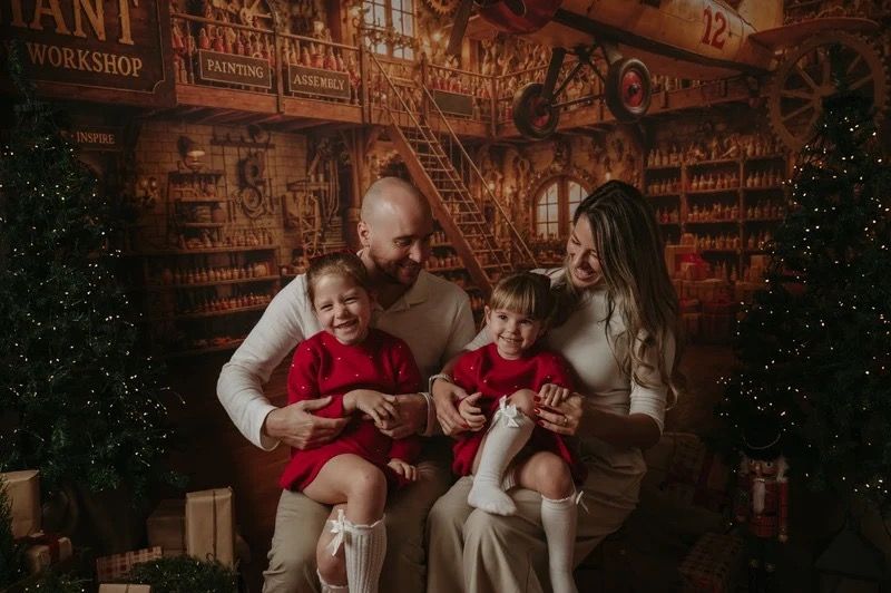 Parents sitting with their children in a festive Christmas setting during a previous session.