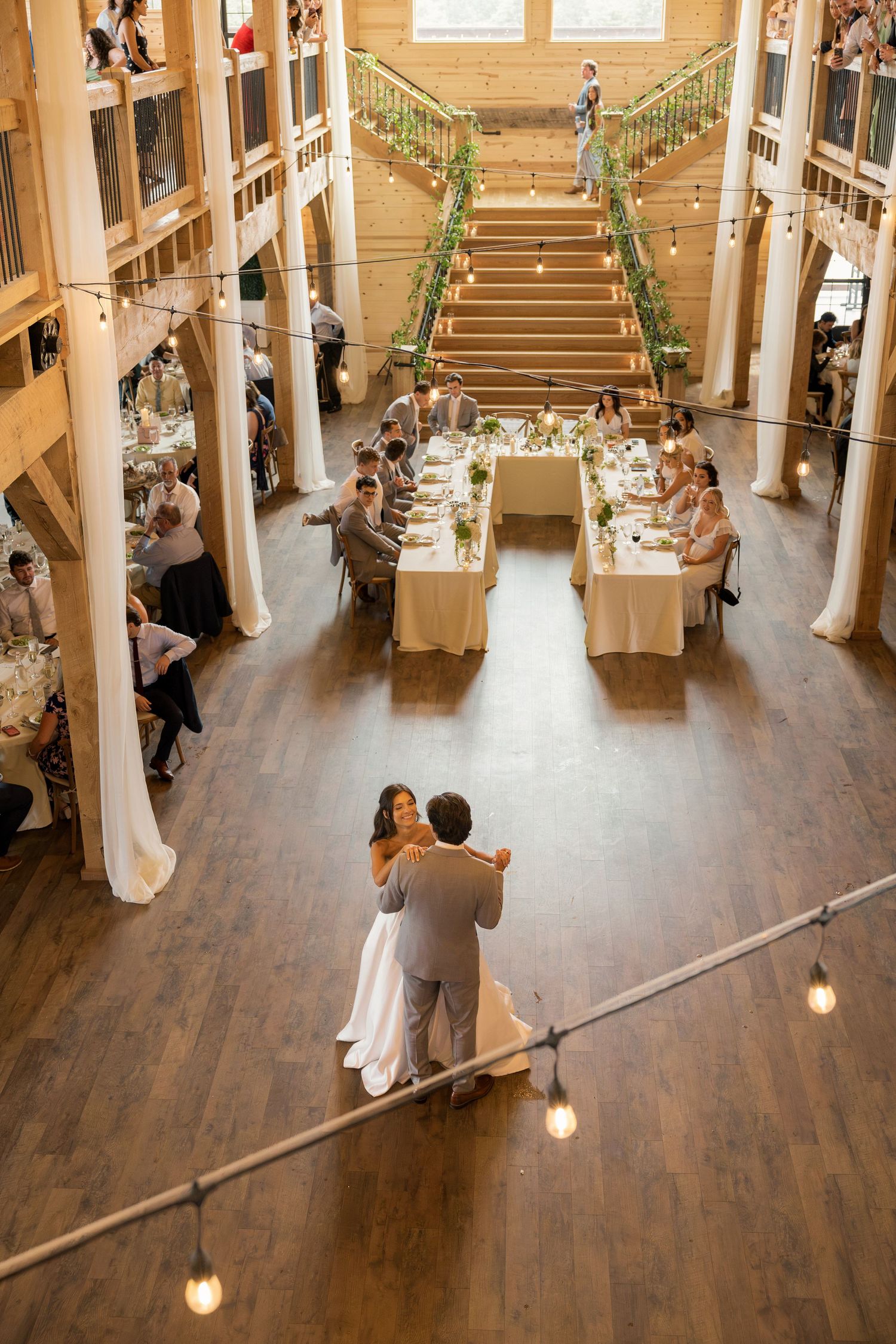 Rustic wooden barn reception with greenery, white florals, and tall taper candles at Tall Oaks Resort near Cleveland, Ohio