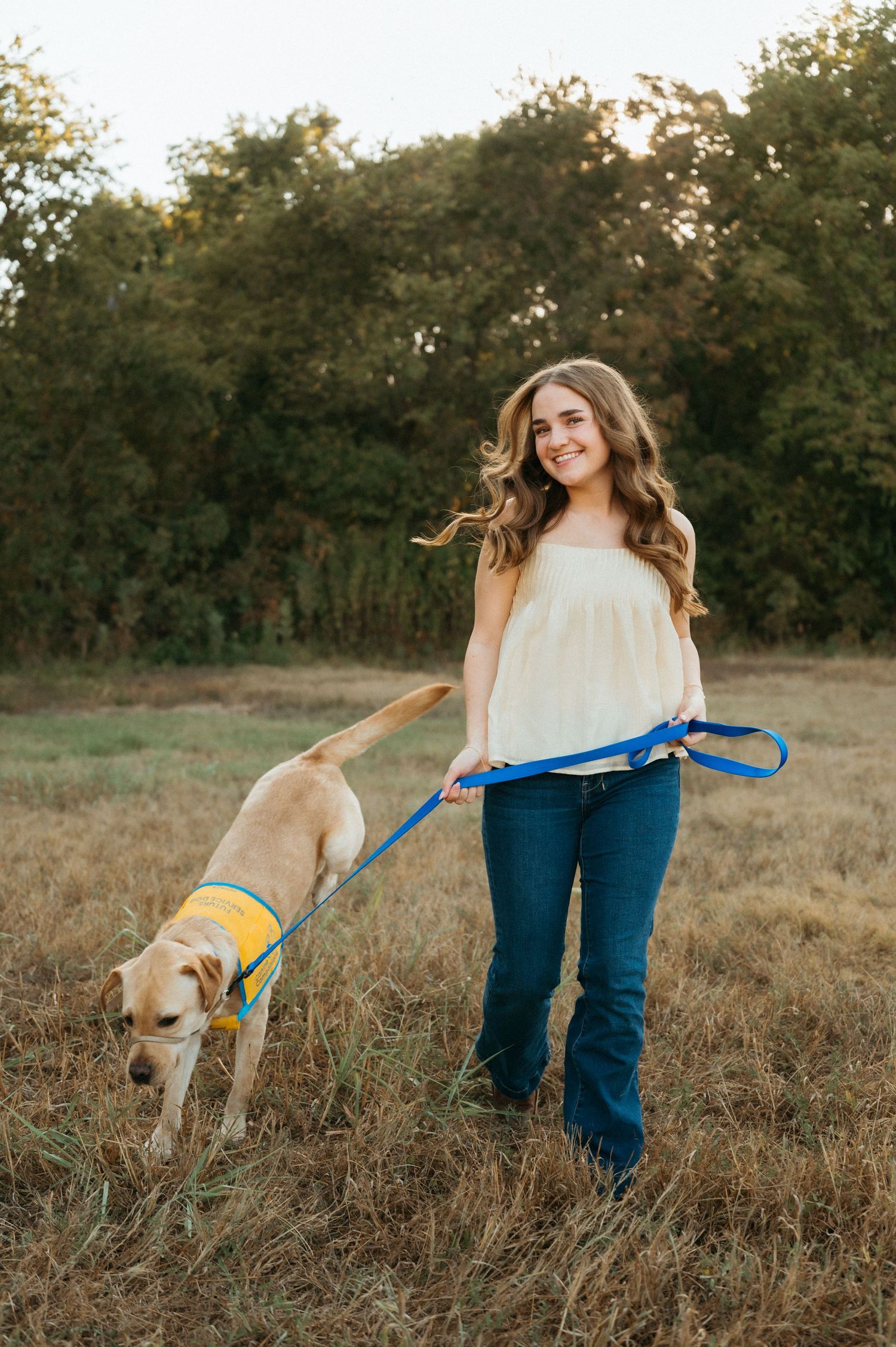 Natural senior photo of Lauren and Opus interacting in a grassy field in Plano, Texas