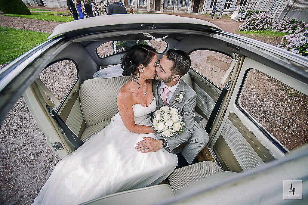 Couple de mariés dans une Coccinelle ancienne à l'Abbaye d'Aulne