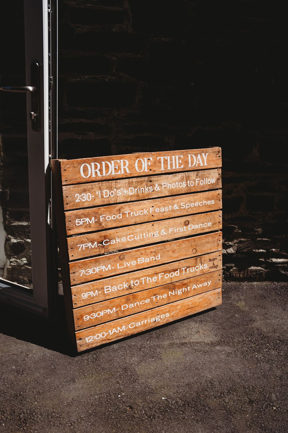 Rustic wooden wedding order of the day sign listing schedule from 2:30PM I Dos to 12AM carriages.