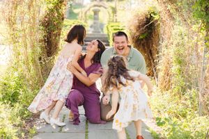 A family of four, with the daughter running to her dad