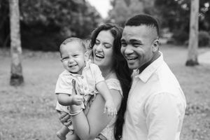 A photo of a family of 3 giggling together