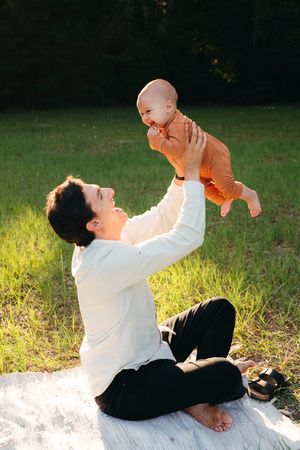 A dad playing with his son, lifting him in the air