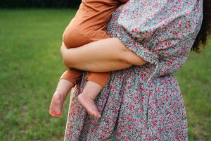 A photo of the feet of a baby held by his mother
