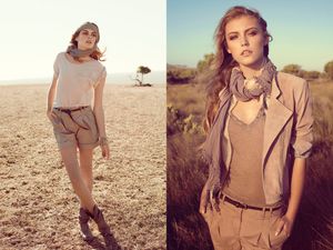 Female model in neutral tones desert fashion shoot wearing shorts and scarf in arid landscape.