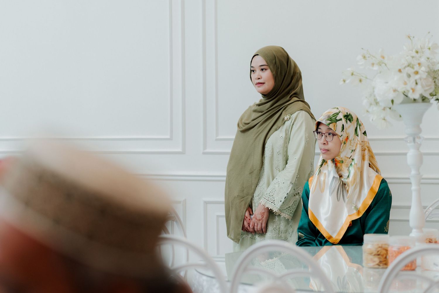 A bride and groom stand together overlooking a serene waterway on their wedding day.