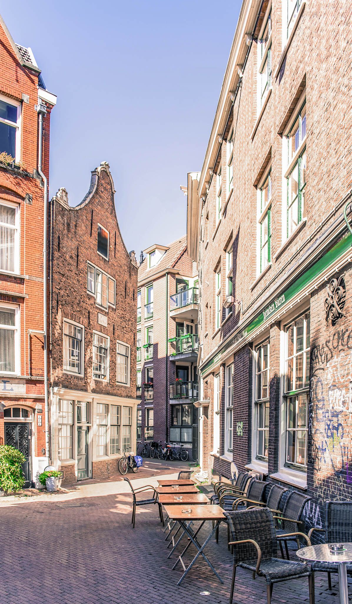 Charming European street scene with historic brick buildings and outdoor cafe seating.