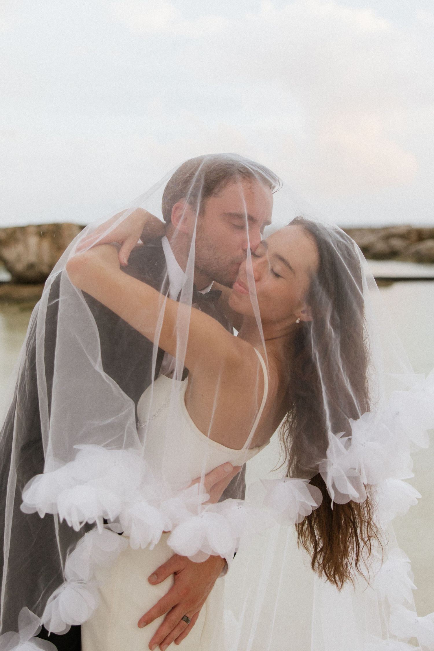 Wind-swept veil photos in black and white showing romantic wedding moments.