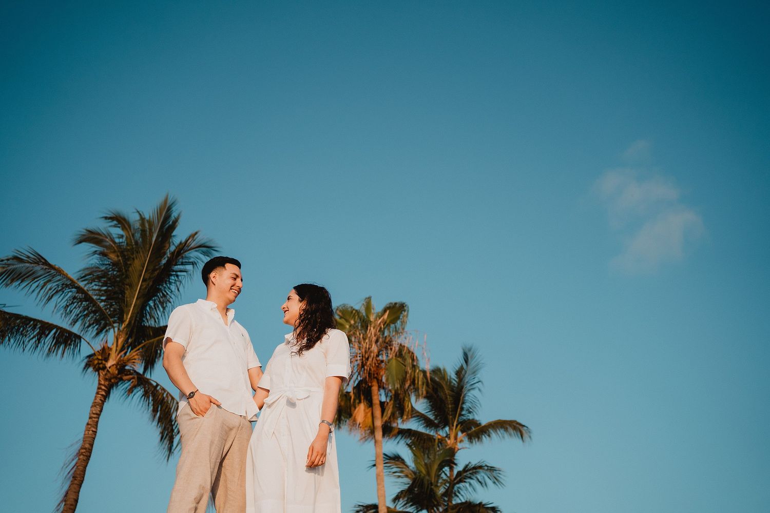 Retrato de pareja entre palmeras durante el atardecer en Mazatlán.