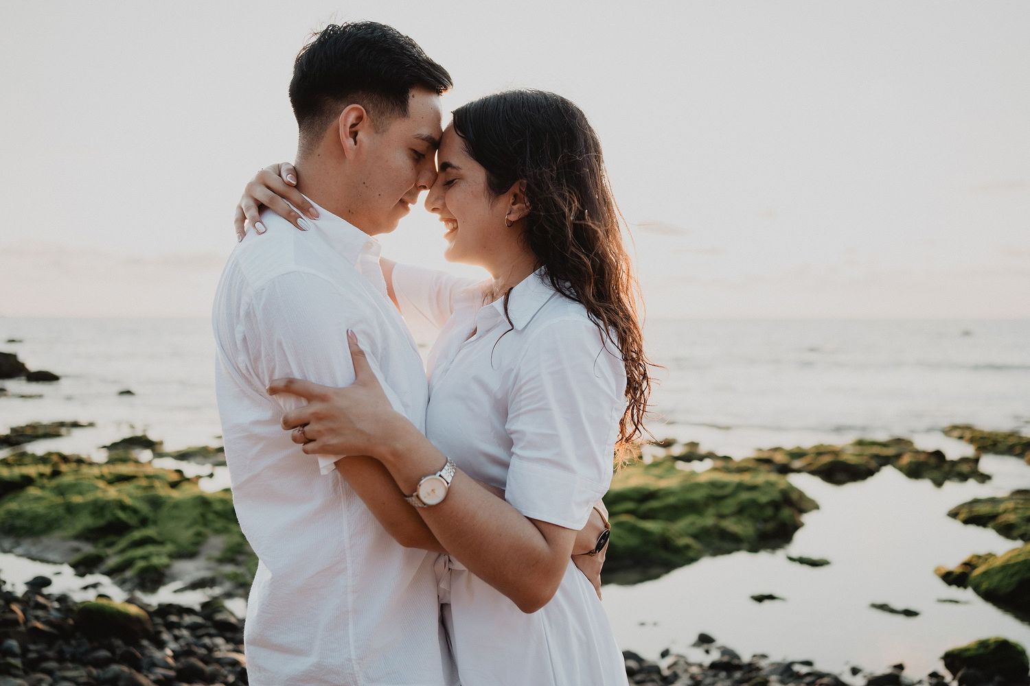 Pareja caminando de la mano por la playa al atardecer en Mazatlán.
