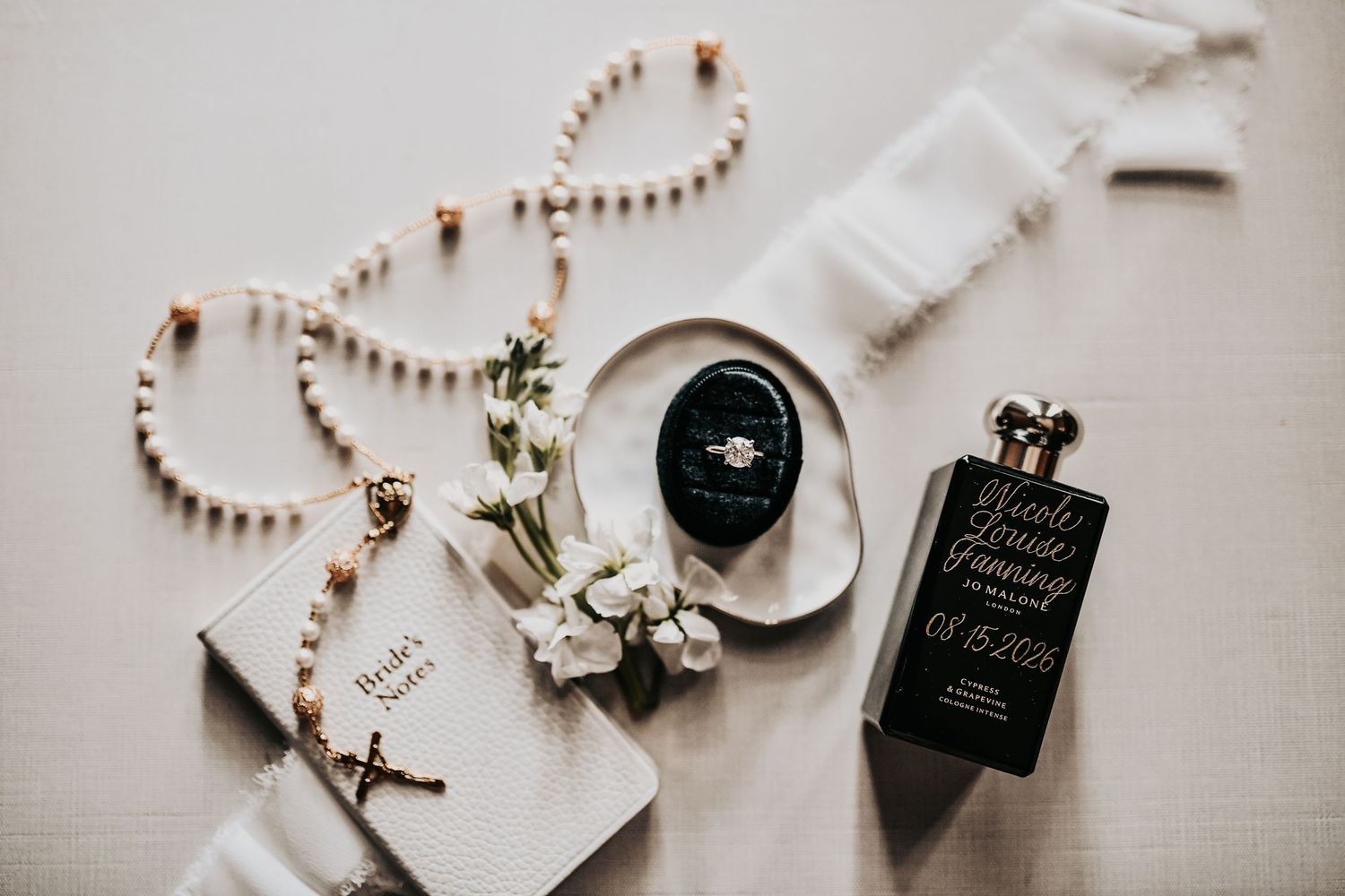 Timeless wedding flat lay with rings, rosary and vow books