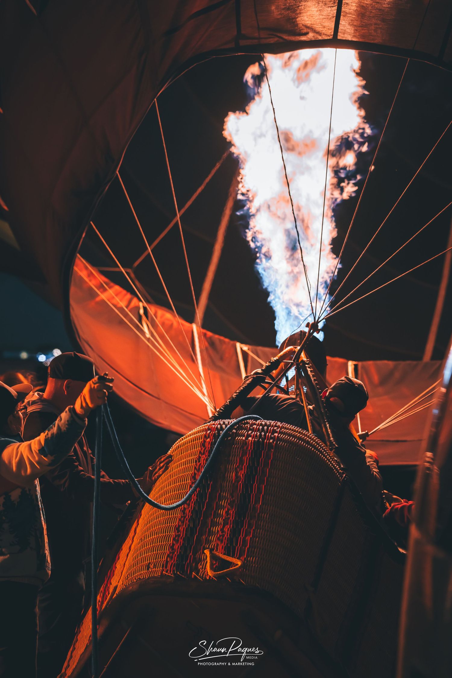 Colorful hot air balloons fill the sky at the Albuquerque International Balloon Fiesta with crowds gathered below.