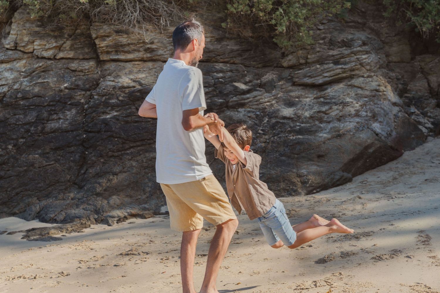 Moment de complicité entre un père et son enfant sur la plage de Saint Lunaire
