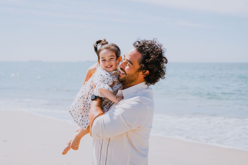 Joyful moment between parent and child playing on sunny beach.