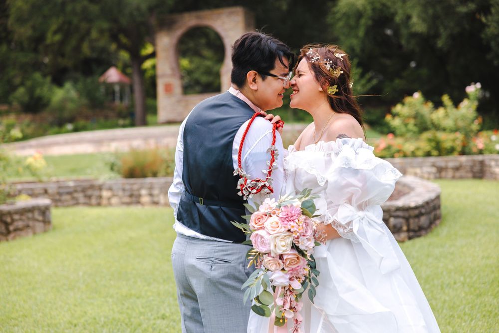 A romantic wedding couple shares intimate moments in a lush garden setting during their outdoor photo session.
