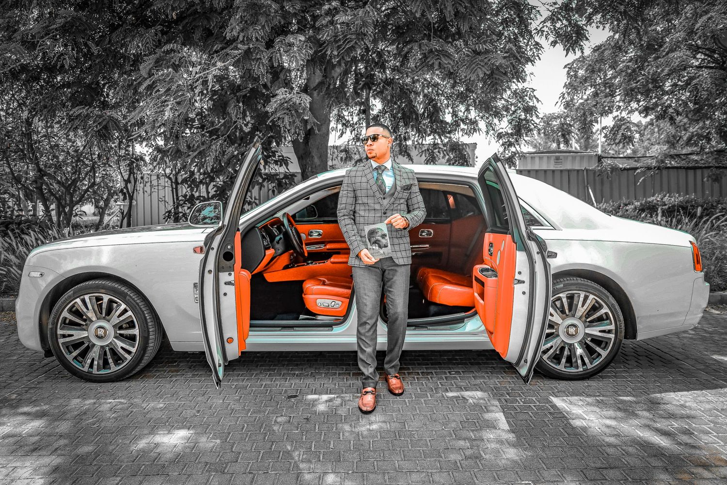 Black and white photo series showing person posing with luxury car with orange interior.