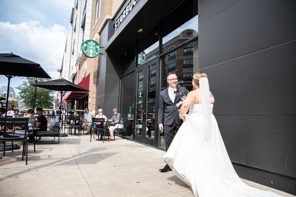 Bride and groom first look outside Starbucks as people look on