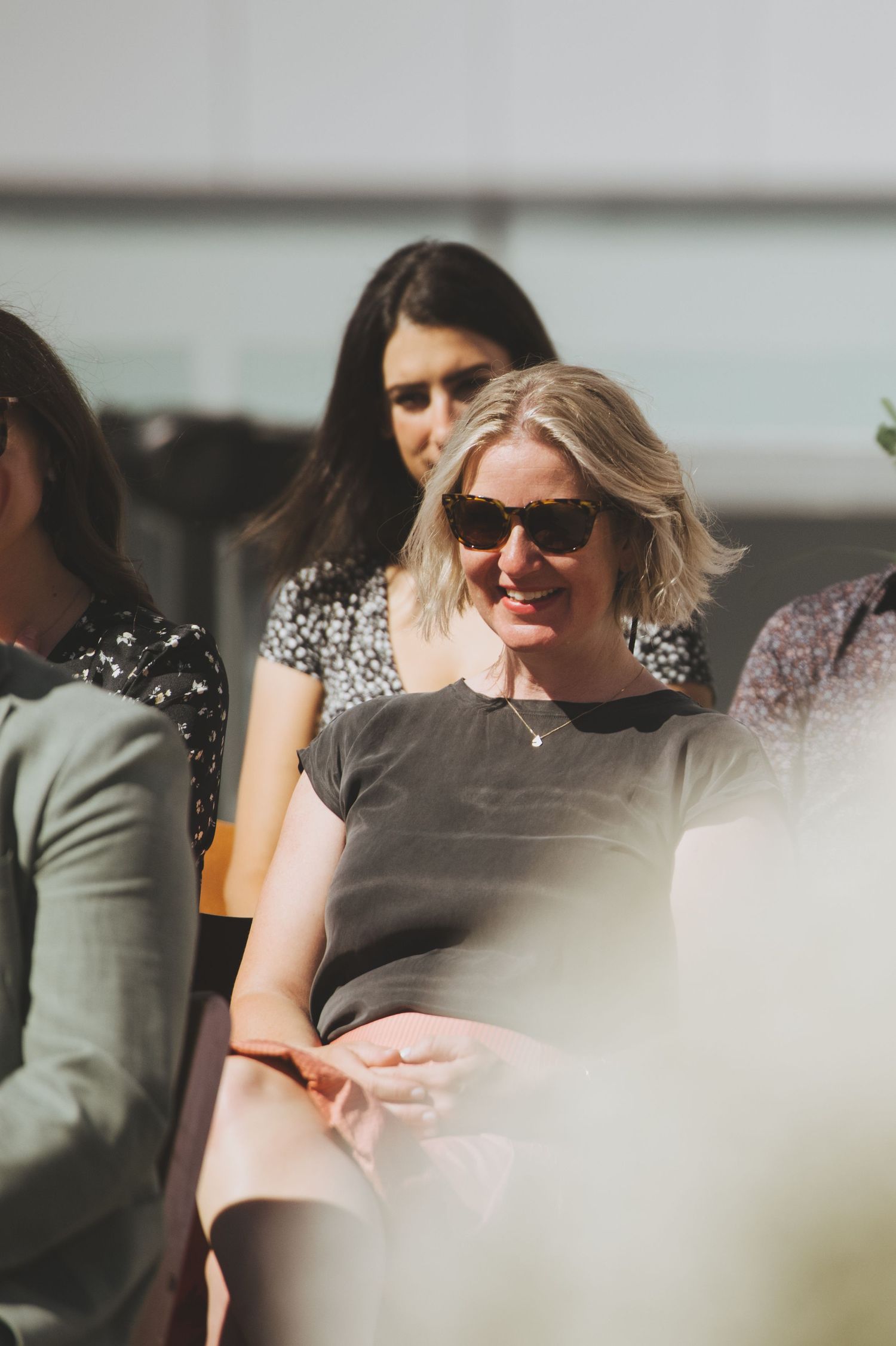 Candid moment of wedding guests enjoying themselves during an outdoor celebration.