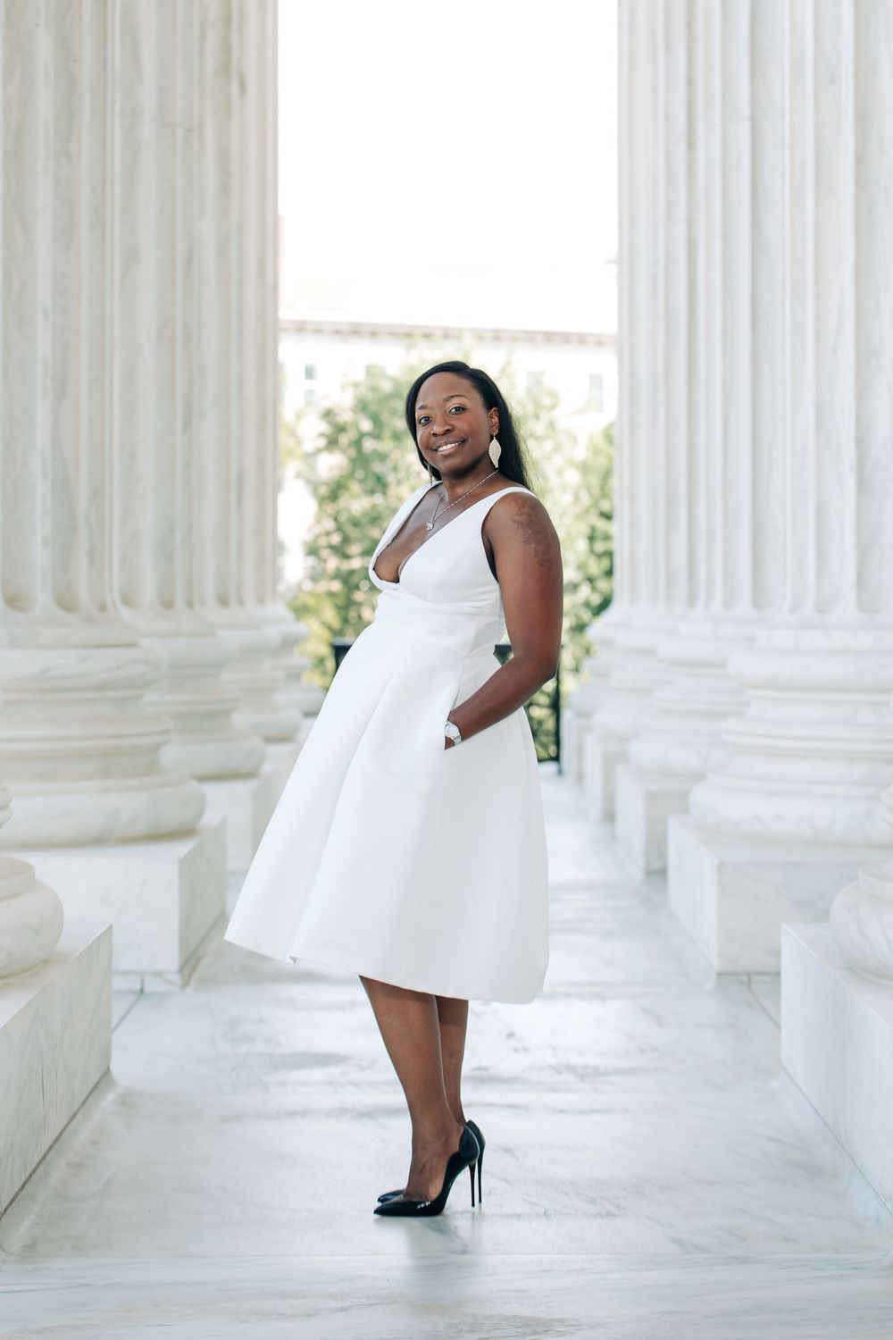 A beautiful white dress photo session with marble columns and pillars in an elegant architectural setting, by Justin Baker Photography.
