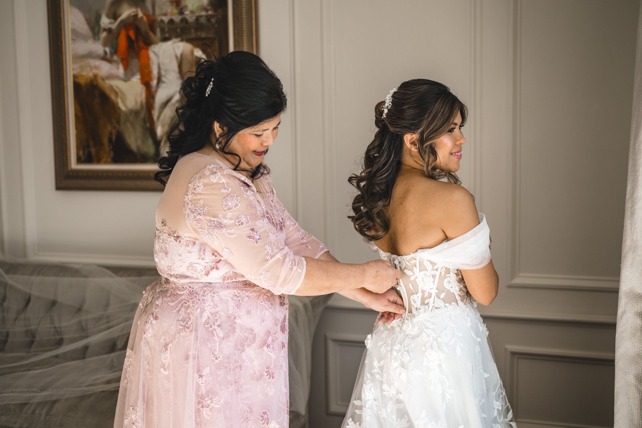Elegant bridal preparation scene in room with gray walls and classic decor.