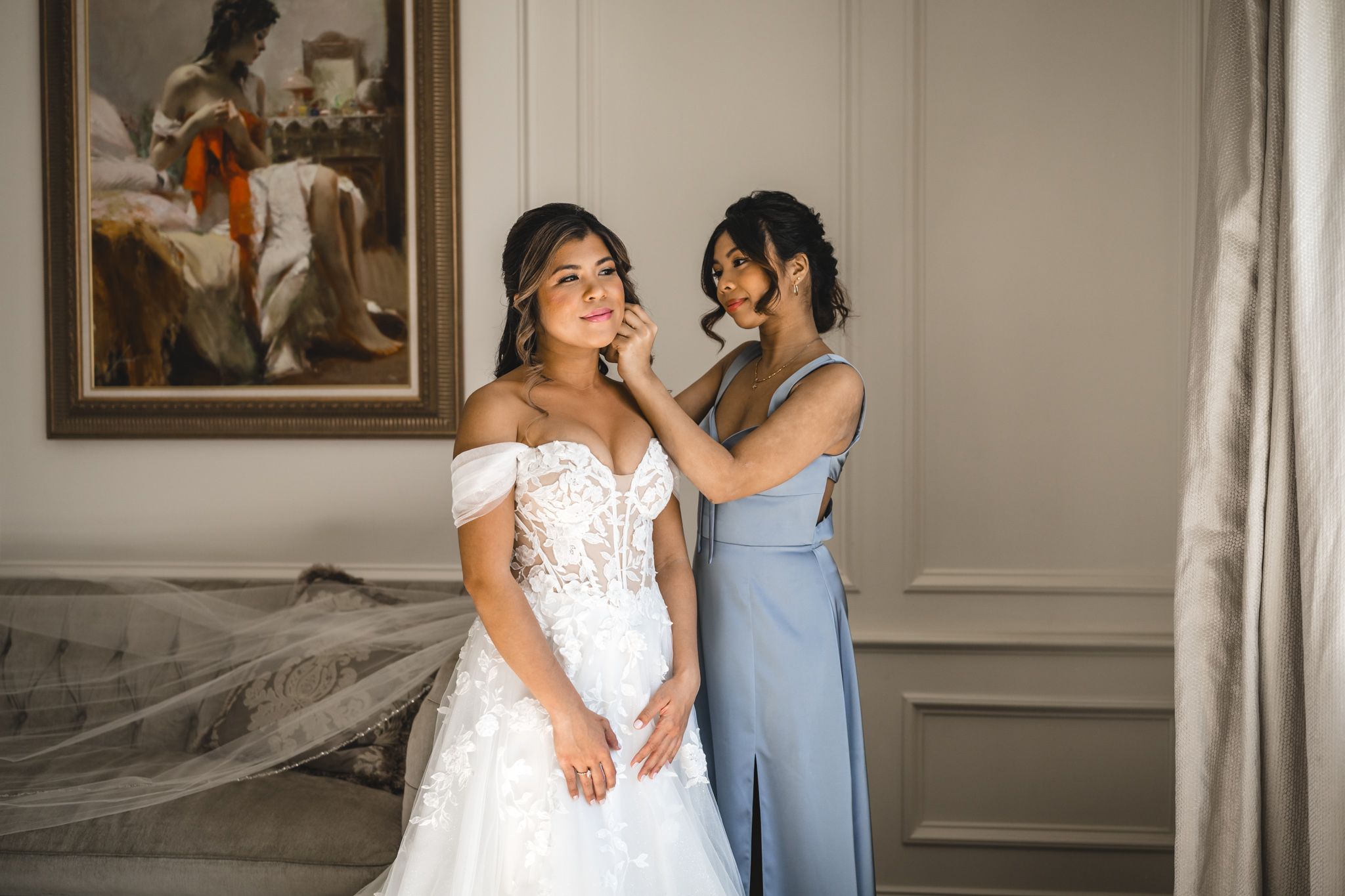 Sunlit bridal preparation moment in an elegant room with classic furnishings.